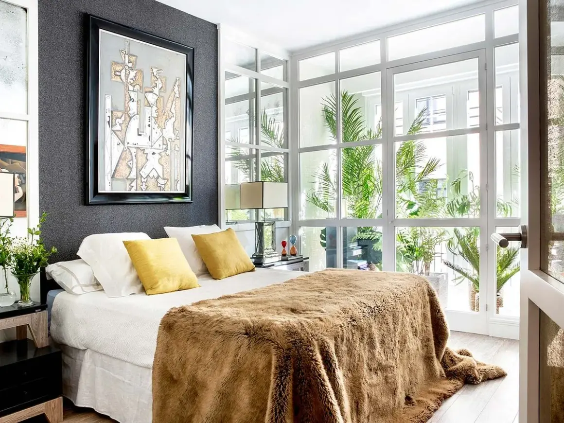 Ideas para diseñar tu habitacion: cama con manta peluda, cuadros abstractos y mucha luz natural.