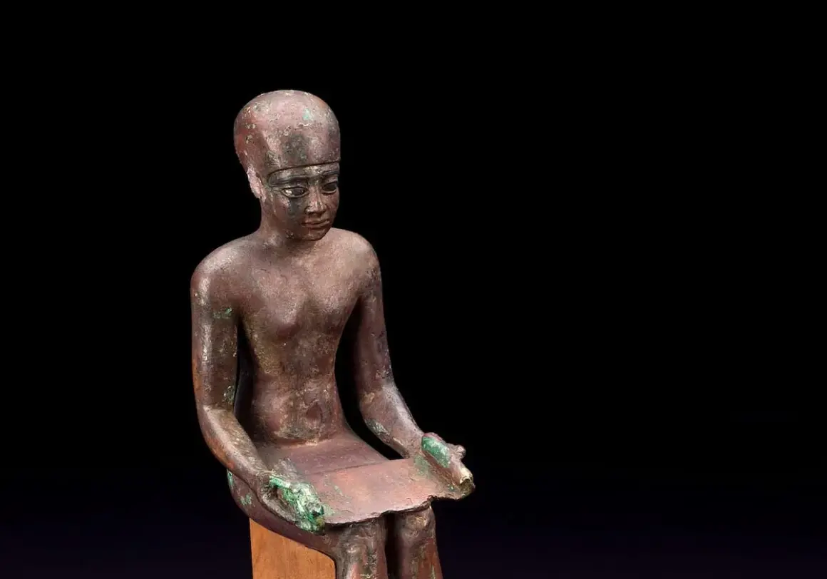 Estatua de bronce de Imhotep, el primer arquitecto de la historia, sentado con un papiro.