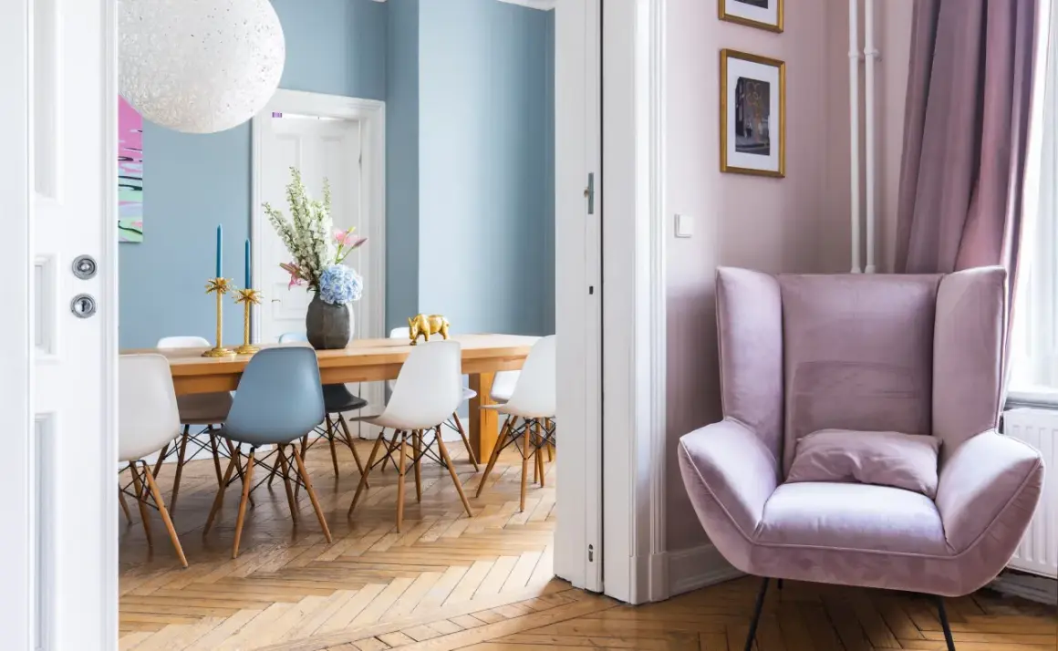 Elegantes casas de diseño interiores: comedor con sillas modernas y un sillón rosa acogedor.