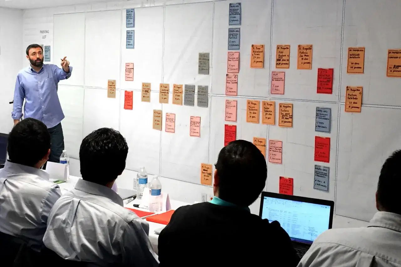 Un equipo colabora en un tablero visual, aplicando principios de lean construction para planificar tareas y optimizar procesos.