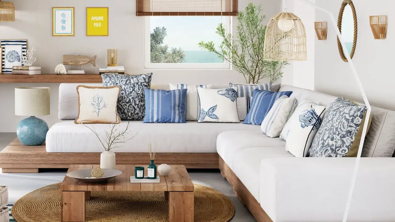 Un sof&aacute; blanco con cojines marinos y un estilo de dise&ntilde;o de interiores y exteriores que evoca la costa.