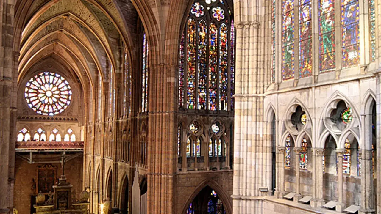 Interior de una catedral con impresionantes vidrieras y arcos que definen la arquitectura g&oacute;tica.