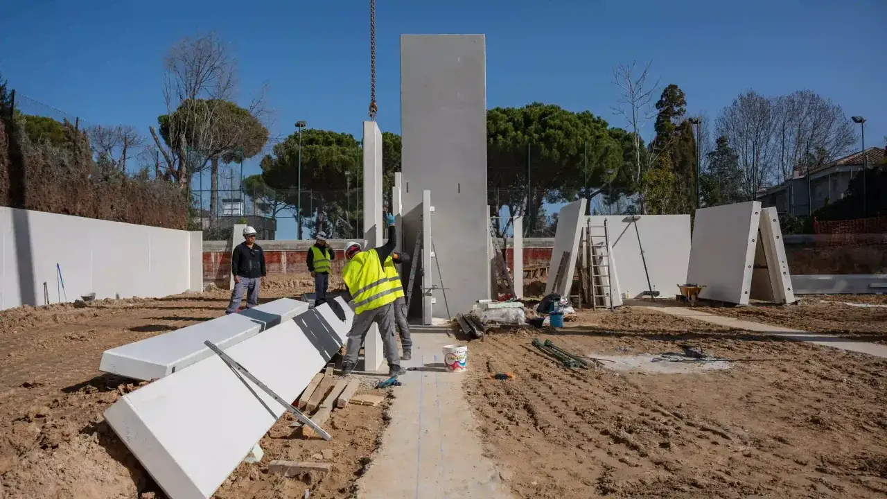 Trabajadores instalan paneles prefabricados en una obra. Un solar urbano se puede construir r&aacute;pidamente con este m&eacute;todo.