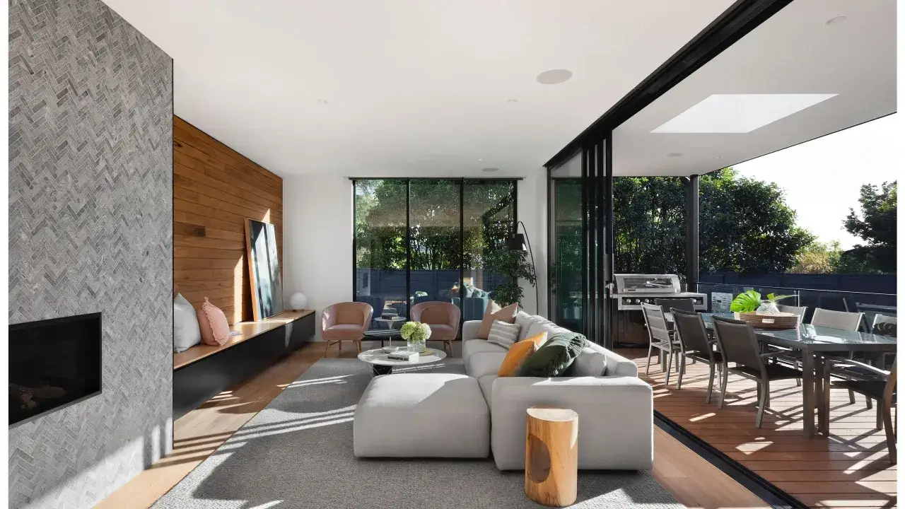 Elegante sal&oacute;n con chimenea de piedra, paredes de madera y grandes ventanales. Un ejemplo de dise&ntilde;o de espacios interiores moderno y acogedor.