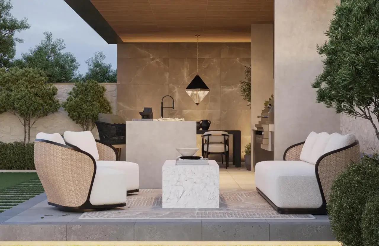 Sof&aacute;s blancos y sillones de mimbre en una terraza con suelos de terrazo, barbacoa y cocina exterior.