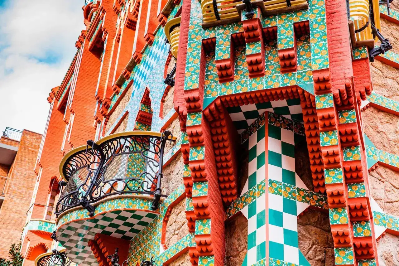 Detalle de arte arquitectura modernista con azulejos coloridos, balcones de hierro forjado y ladrillo visto.