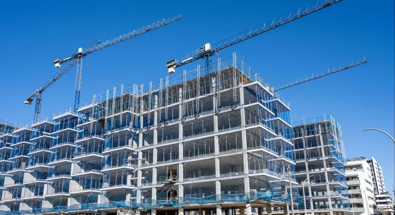 Edificio en construcción con grúas, parte de un proyecto de construccion de viviendas.