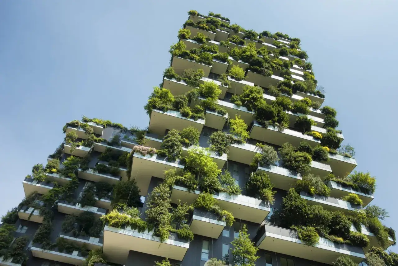 Edificio con balcones repletos de vegetaci&oacute;n, un ejemplo de dise&ntilde;o sostenible que integra la naturaleza en la arquitectura urbana.