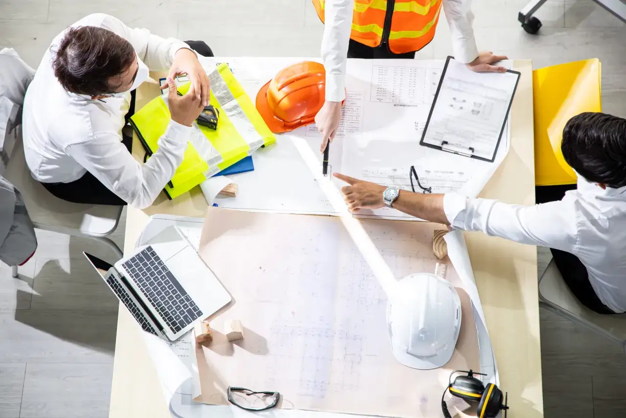 Ingenieros discuten planos de construcci&oacute;n. Se preguntan qui&eacute;n puede firmar un plan de seguridad y salud.