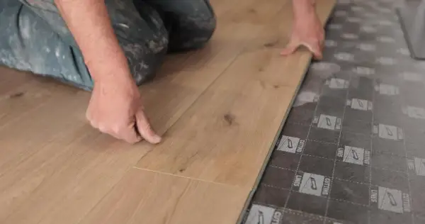 Man instalando tarima flotante, una forma fácil de cambiar suelo sin obra.