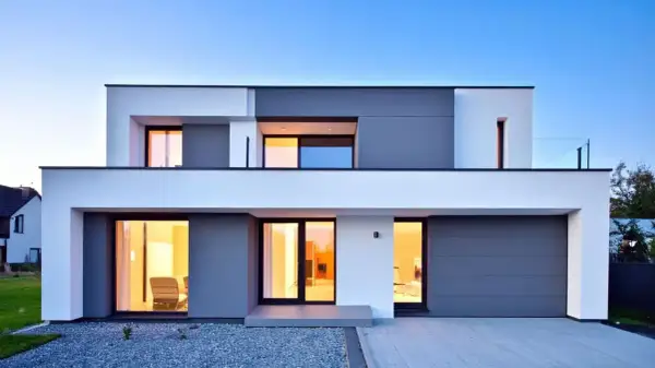 Moderna casa con amplios ventanales y puerta de garaje gris. Un ejemplo de construcción de viviendas contemporáneas.