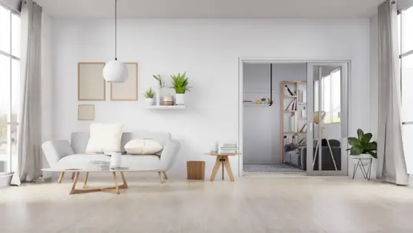 Sala de estar minimalista con sofá gris, mesa de centro de madera y suelo de madera clara, mostrando varios tipos de suelo.