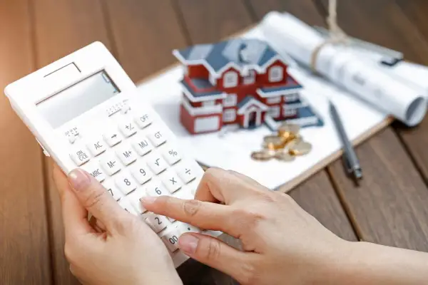 Calculadora en mano, planificando la compra de una casa. Esto es autopromoción: invertir en tu futuro.