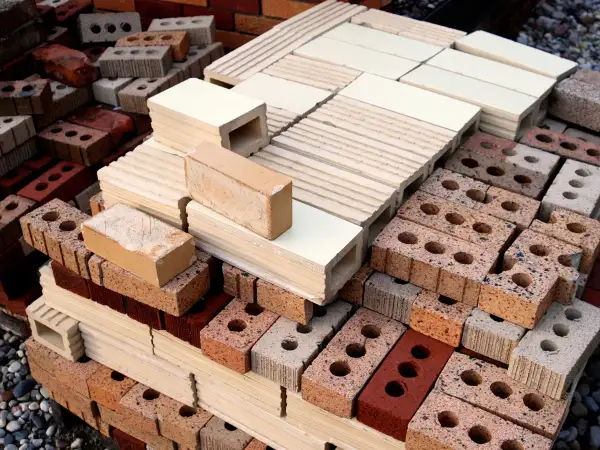 Montón de ladrillos de construcción tradicional, apilados en diferentes tamaños y colores, listos para crear estructuras sólidas.